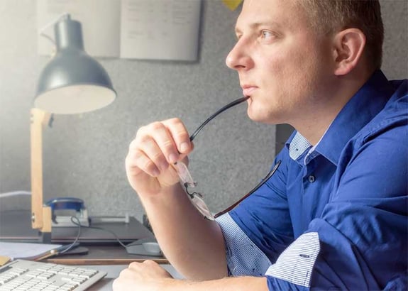 mies pitelee silmälaseja kasvoilla mietteliäs ilme