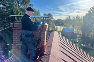 Nuohooja Janne Liusvaara työssään asiakkaan kodin katolla.