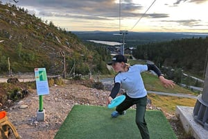 Polkeva ruohonleikkaaja pelaamassa frisbeegolfia Rukalla, Kuusamossa